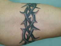 TATUAJE BRAZALETE DE ESPINOS EN BRAZO