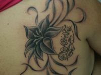 TATUAJE FLOR, HOJAS Y NOMBRE EN ESPALDA